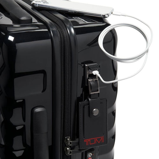 Black suitcase with USB port and TUMI branding on a white background