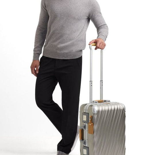 Person holding a silver suitcase on a white background