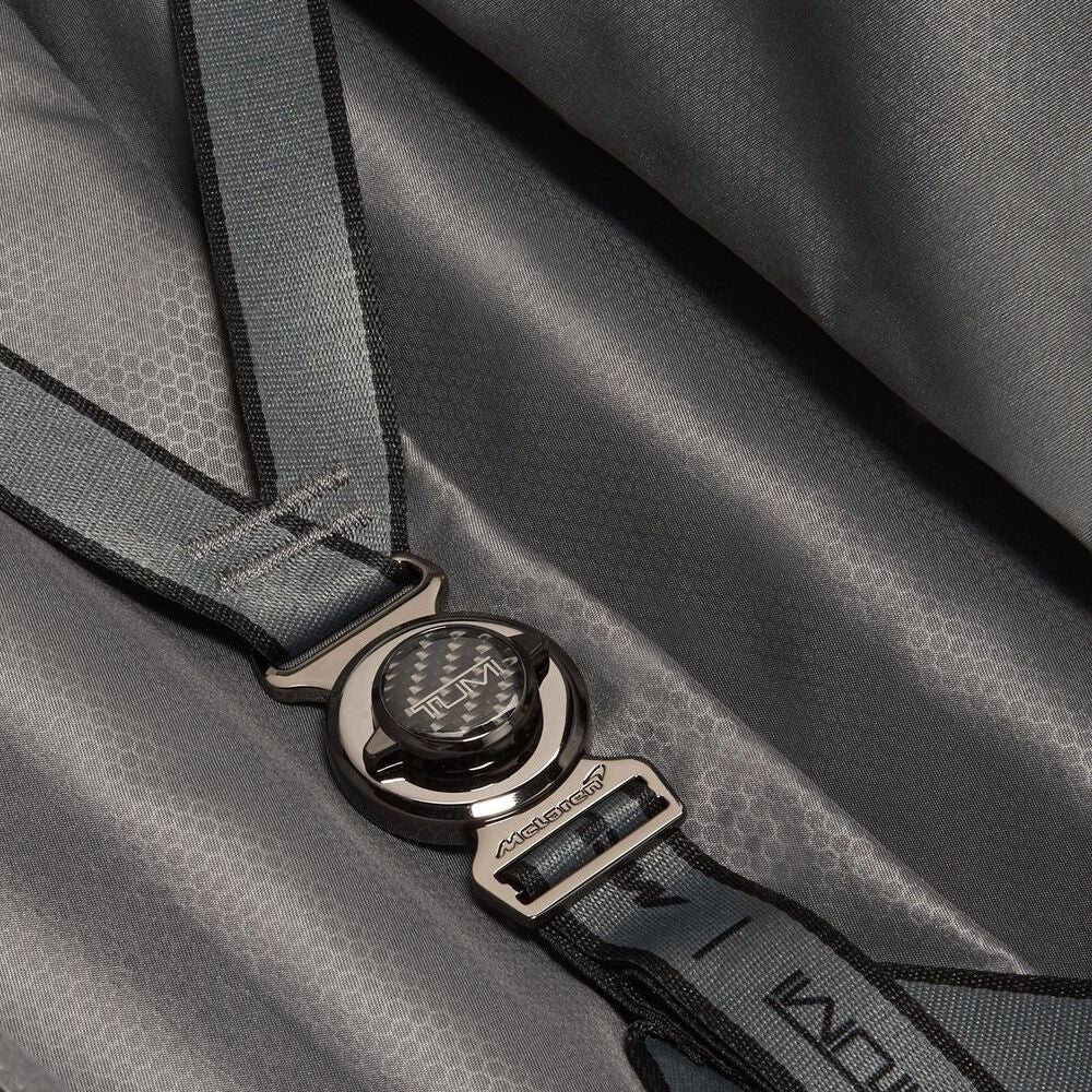 Close-up of a gray bag with a brand logo on a matching strap.