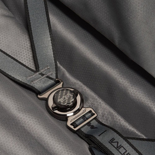 Close-up of a gray bag with a brand logo on a matching strap.