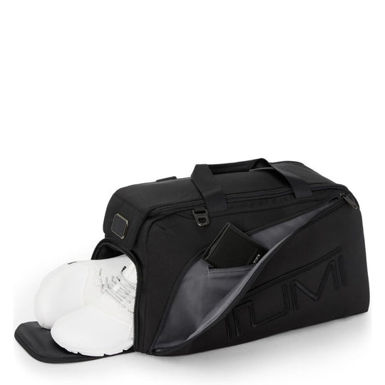 Black sports bag with a clear compartment containing white shoes on a white background