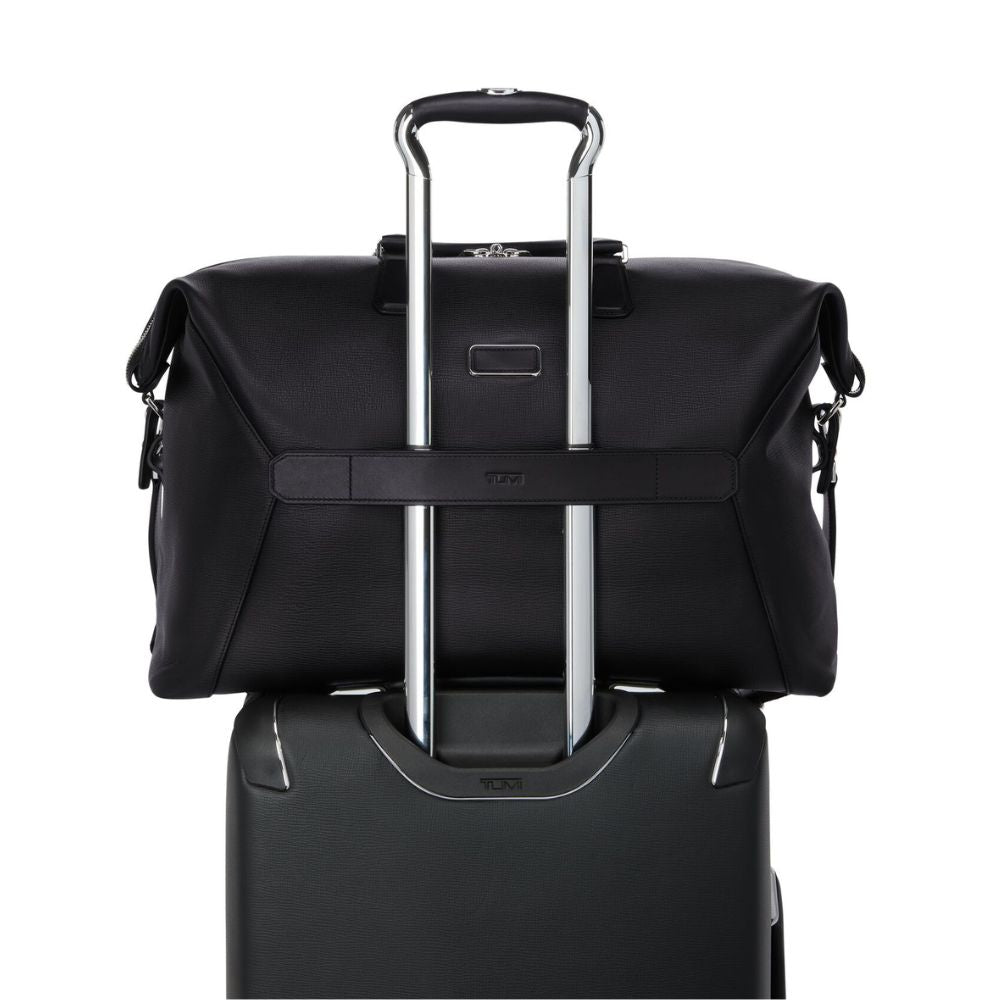 Black suitcase with a matching roll-top bag on a white background