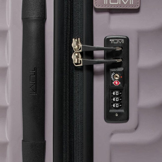 Close-up of a Tumi suitcase with a zipper and lock mechanism.