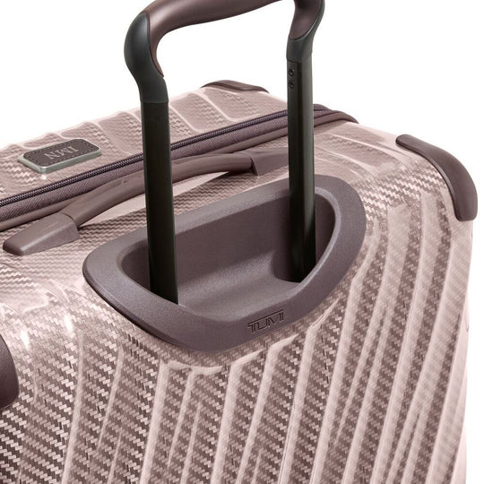 Close-up of a textured suitcase with a handle on a white background