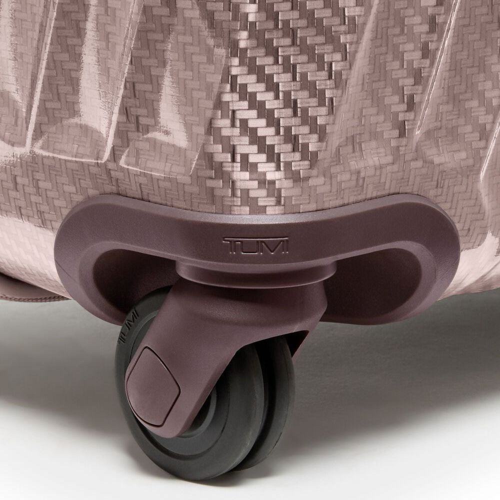 Close-up of a suitcase wheel with TUMI branding on a light background