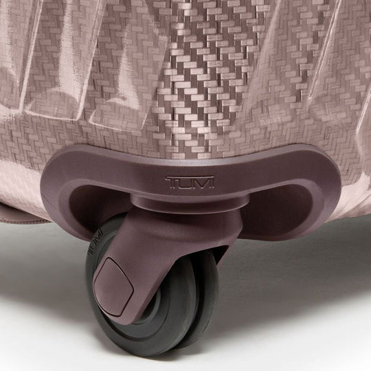 Close-up of a suitcase wheel with TUMI branding on a light background