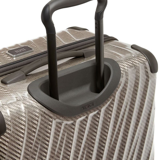 Close-up of a textured suitcase with a handle on a white background