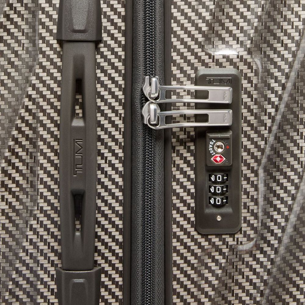 Close-up of a textured suitcase with a zipper and combination lock.