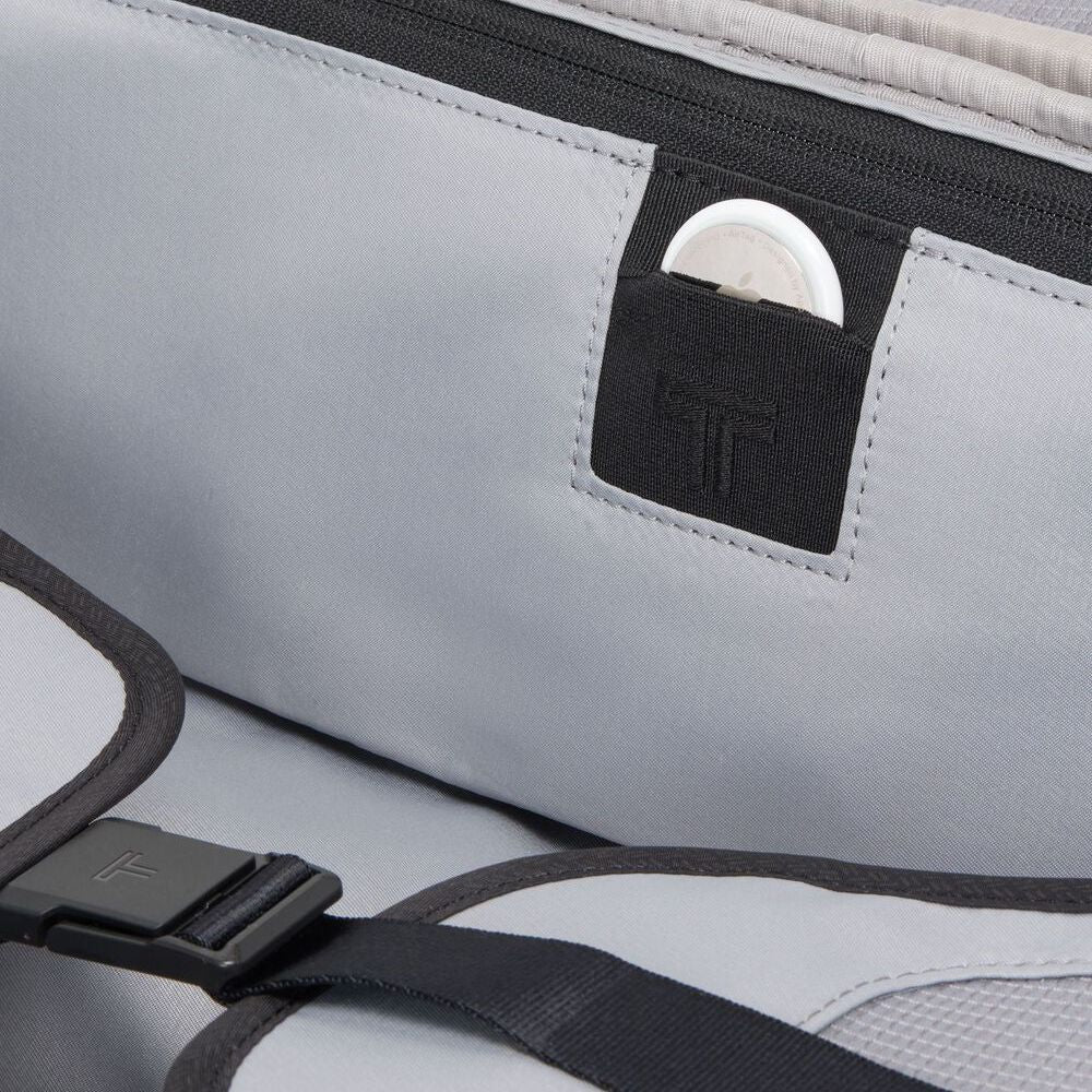 Gray bag with a black strap and a small pocket on a gray background