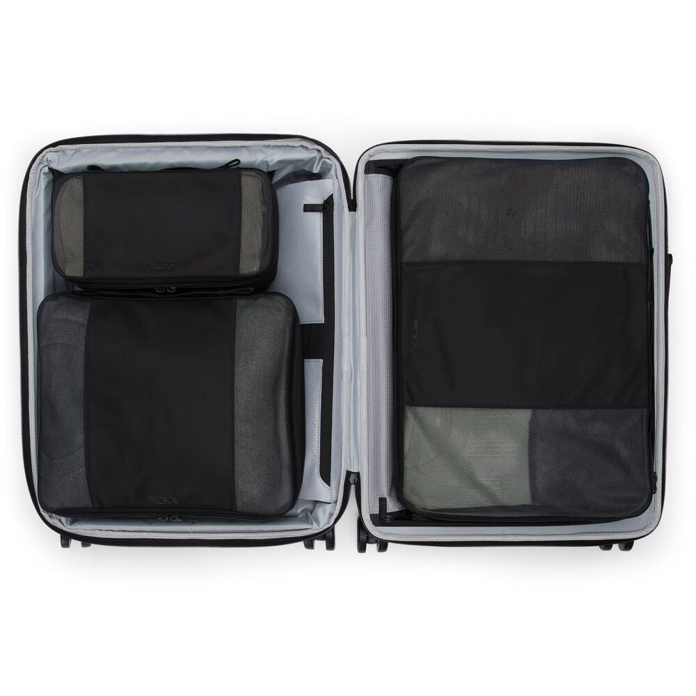 Open suitcase with black packing cubes inside on a white background