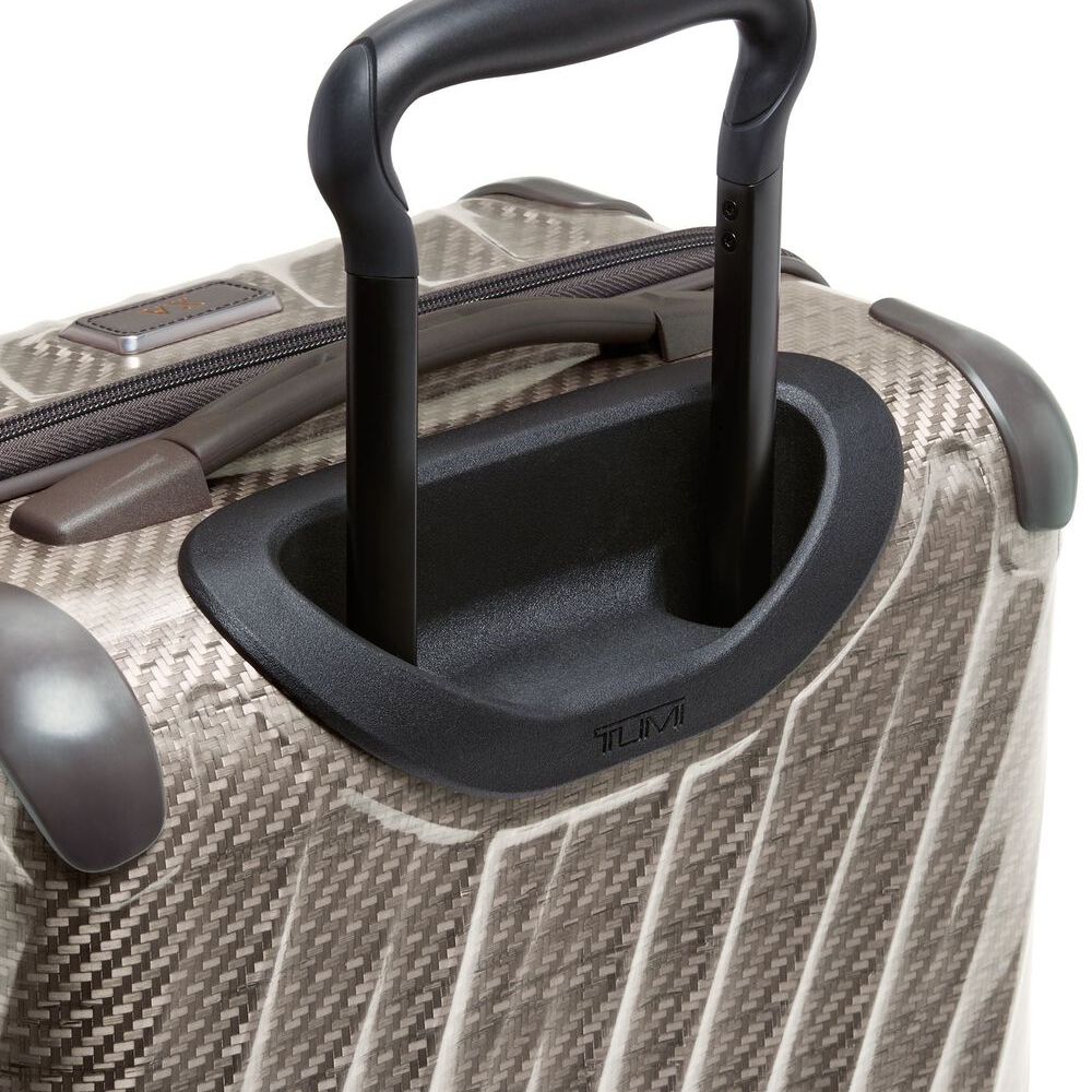 Close-up of a textured suitcase handle and body on a white background