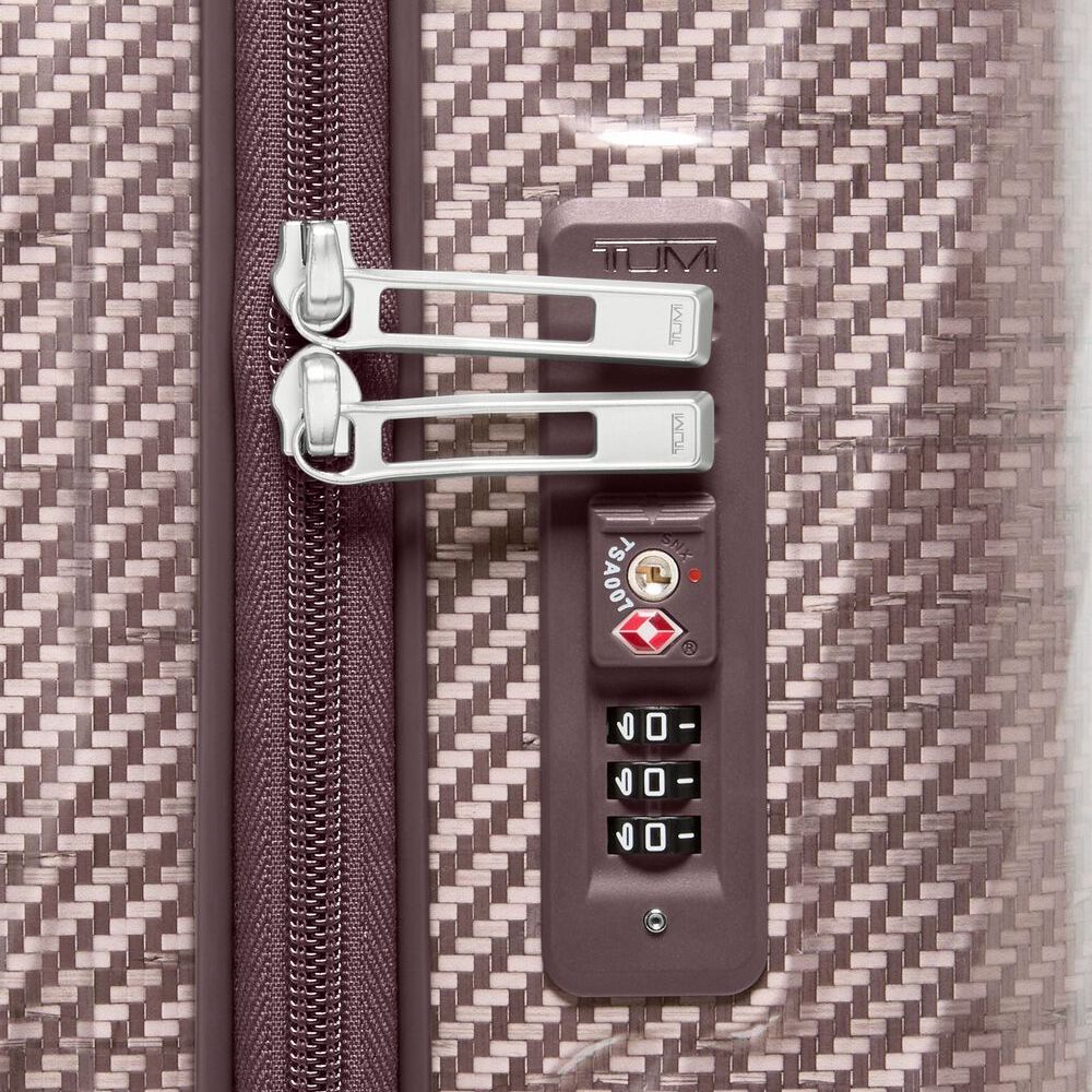 Close-up of a suitcase with a TSA lock on a textured surface