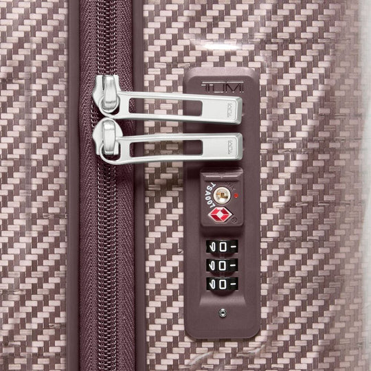 Close-up of a suitcase with a TSA lock on a textured surface