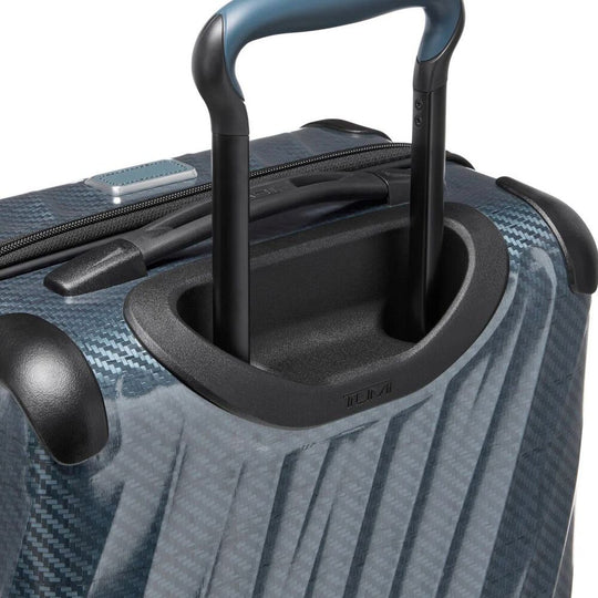 Close-up of a blue suitcase with a black handle and wheels on a white background