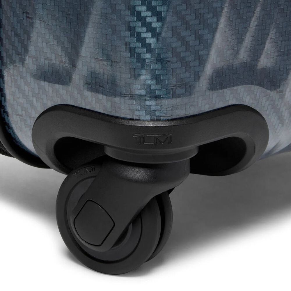Close-up of a suitcase wheel on a textured surface
