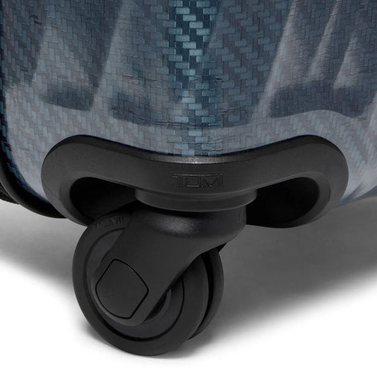 Close-up of a suitcase wheel on a textured surface