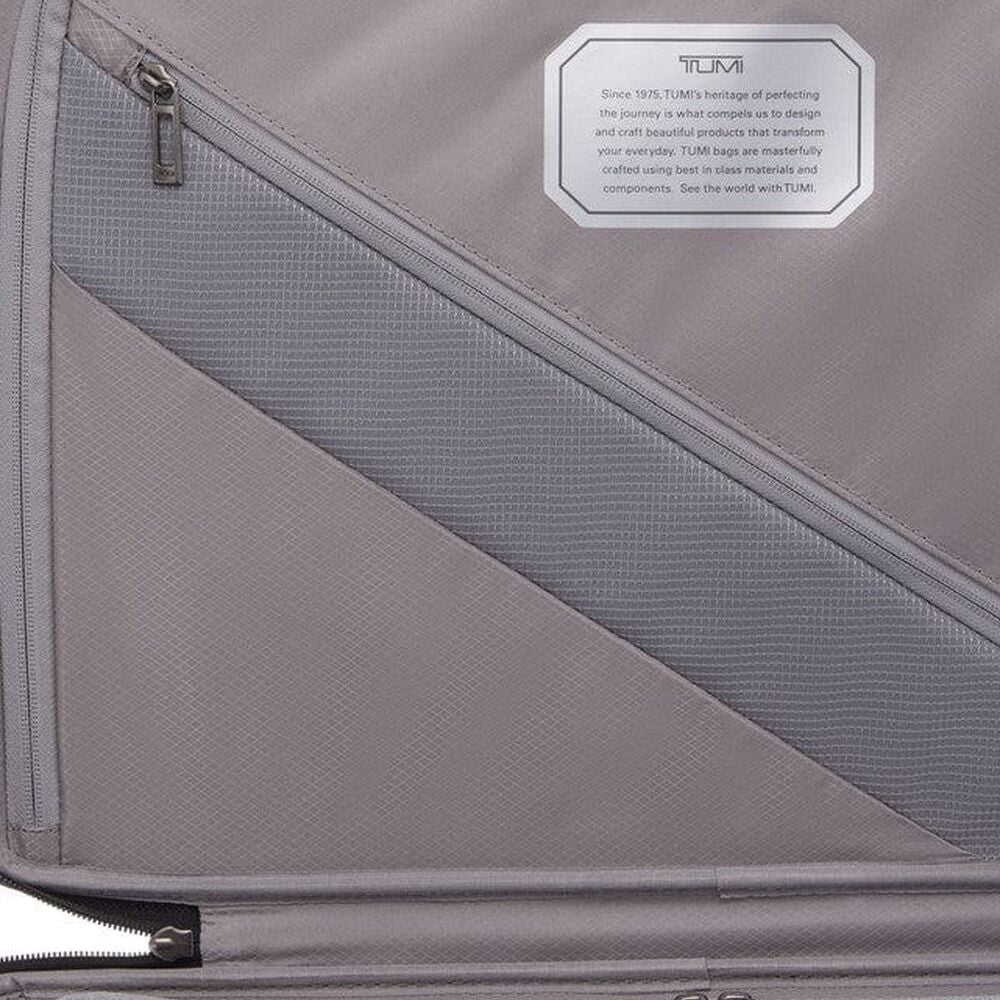 Gray suitcase with a Tumi label on a gray background