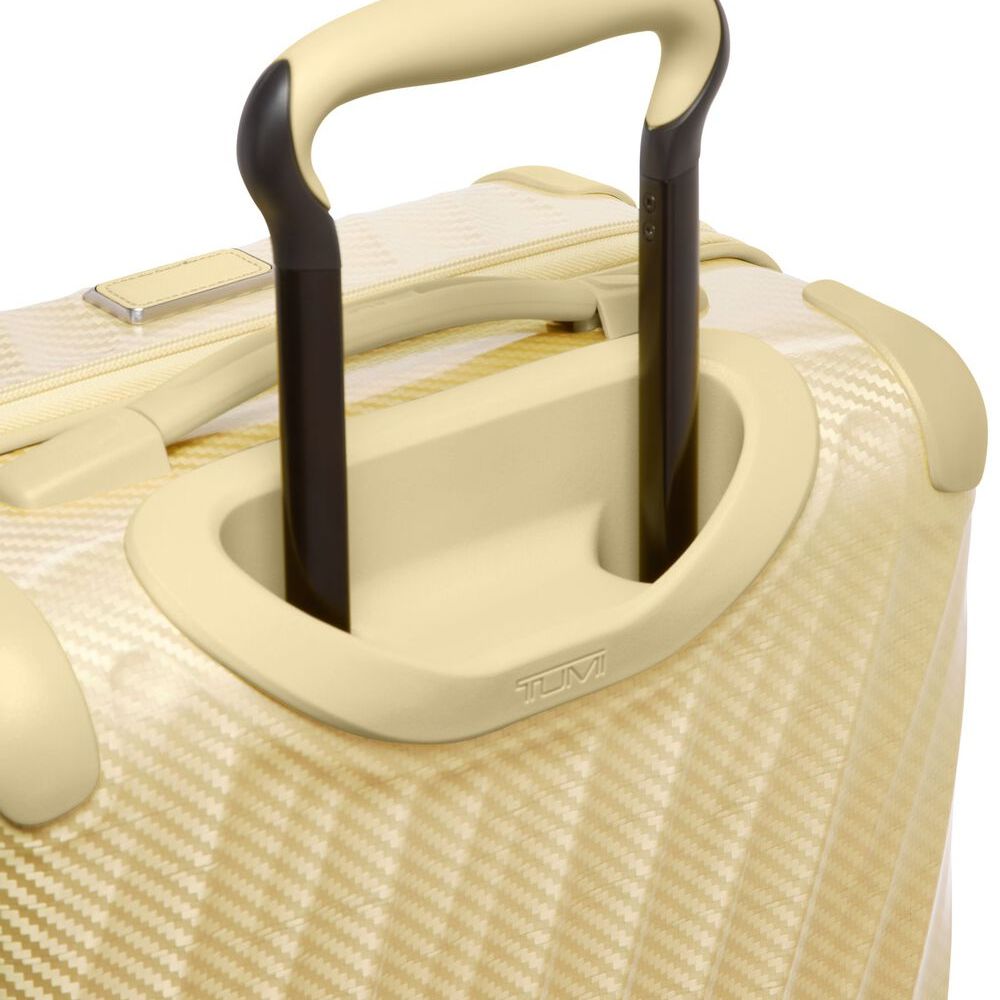 Close-up of a beige suitcase with a black handle on a white background