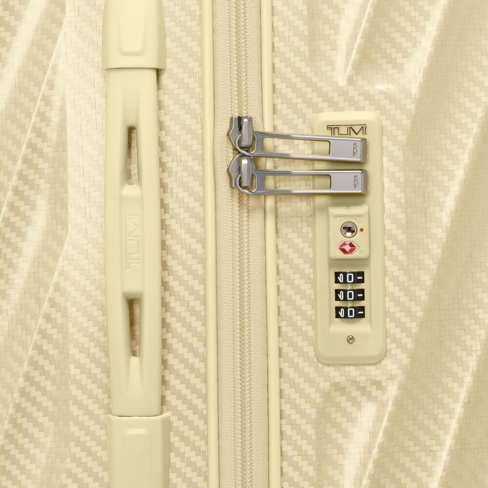 Beige suitcase with a combination lock on a textured beige background