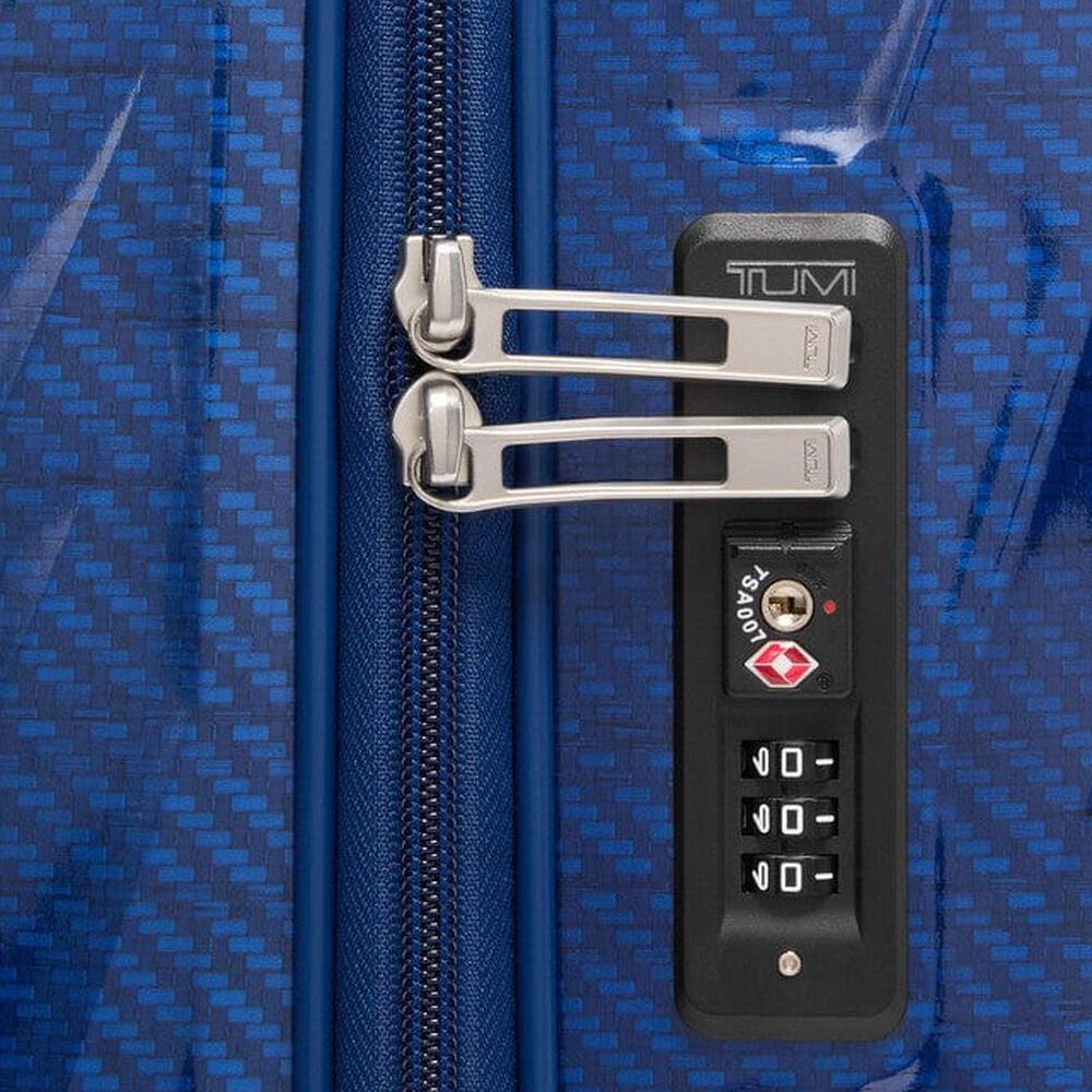 Close-up of a blue suitcase with a TSA-approved lock on a matching blue background