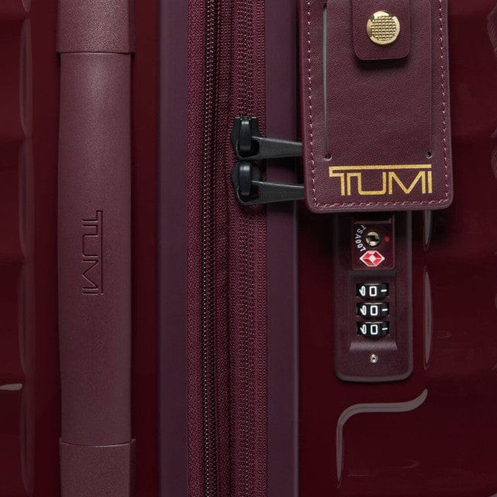 Close-up of a TUMI suitcase with a zipper and combination lock.
