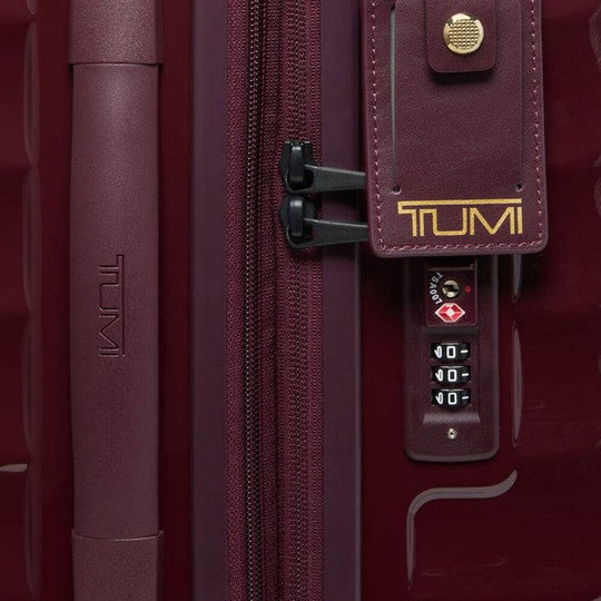Close-up of a TUMI suitcase with a zipper and combination lock.