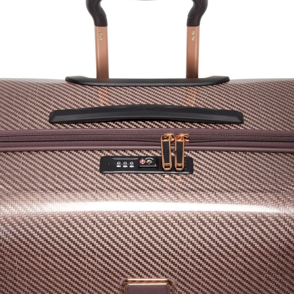 Close-up of a handle and combination lock on Blush Variant of TUMI Tegra-Lite Extended Packing Case With USB-C And Spinner Wheels: Model Number 144794-1060 